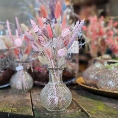 Klein glazen vaasje met roze droogbloemen