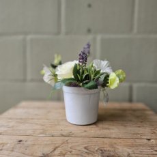 Zijden bloemen in een witte glazen pot