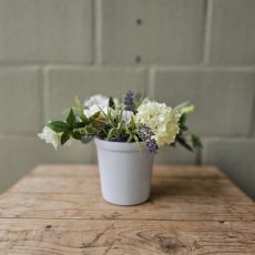 Zijden bloemen in een witte glazen pot
